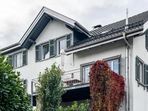 a white building with a balcony with plants on it at Ferienwohnung Lauterach in Lauterach