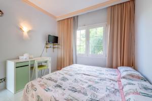 a bedroom with a bed and a desk and a window at Villa Son Ferrer in Santa Ponsa +18 photos