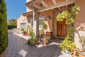 a porch of a house with a bench and plants at Villa Son Ferrer in Santa Ponsa