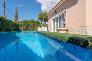 a blue swimming pool in front of a house at Villa Son Ferrer in Santa Ponsa