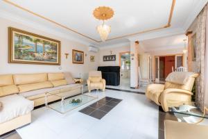 a living room with a couch and chairs at Villa Son Ferrer in Santa Ponsa
