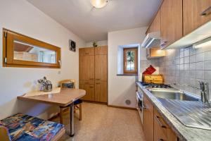 a kitchen with wooden cabinets and a wooden table at Wohnung Arnika Stücklhof in San Genesio Atesino