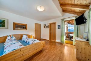 a bedroom with a bed and a television in a room at Wohnung Arnika Stücklhof in San Genesio Atesino +29 photos