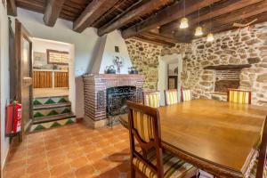 a dining room with a table and a fireplace at Masía Can Garriga, Casa Gran in Girona