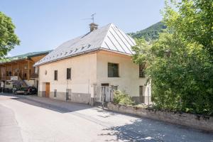 a white house with a metal roof on a street at Rose Des Neiges in Valloire