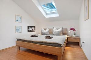 a bedroom with a large bed with a skylight at Haus A Cappella B6 in Binz +21 photos