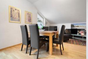 a dining room with a wooden table and black chairs at Haus A Cappella B6 in Binz