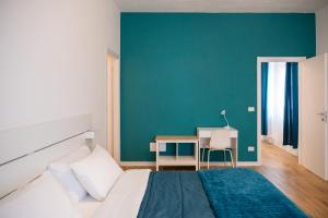 a bedroom with a bed with a desk and a green wall at Oltremare in Molfetta
