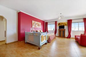a bedroom with a bed and a red wall at Villa Delphin in Lagos