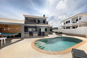 a house with a swimming pool on a patio at Villa Delphin in Lagos