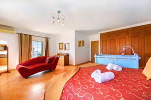 a bedroom with a red bed and a red chair at Villa Delphin in Lagos +37 photos