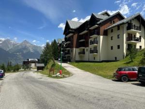a building with cars parked on the side of a road at Appart valfrejus in Modane