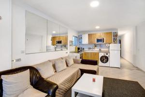 a living room with a couch and a kitchen at Los Molinos 538 in Maspalomas