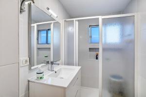 a white bathroom with a sink and a shower at Los Molinos 538 in Maspalomas +12 photos