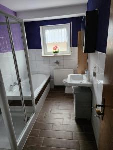 a bathroom with a tub and sink and a window at Ferienwohnung Metz in Waldberg +25 photos