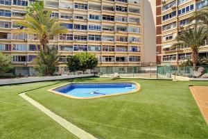 a yard with a swimming pool in front of a large building at Los Molinos 538 in Maspalomas