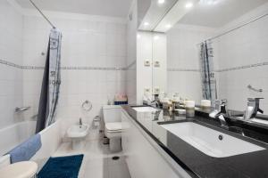 a bathroom with two sinks and a toilet and a tub at Casa do Mar na Figueira da Foz in Figueira da Foz +21 photos