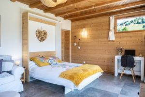 a bedroom with a bed and a desk and a chair at La scierie de la grande ourse in Albiez-Montrond