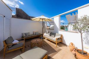 a patio with a table and chairs and an umbrella at Casa Max in Artá