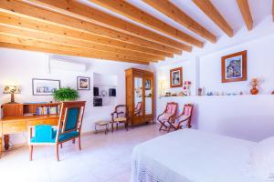 a bedroom with a bed and a desk and chairs at Can Murons in Fornalutx