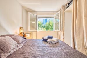 a bedroom with a bed with a window at L'appartement d'Olympe in Périgueux