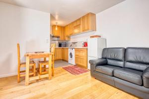 a living room with a couch and a table and a kitchen at L'appartement d'Olympe in Périgueux +13 photos