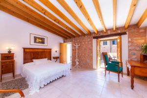 a bedroom with a bed and a desk and a piano at Can Murons in Fornalutx