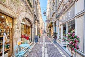 an alley in an old town with shops at L'appartement d'Olympe in Périgueux