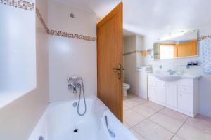 a bathroom with a tub and a toilet and a sink at Can Murons in Fornalutx +19 photos
