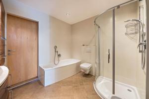 a bathroom with a tub and a toilet and a shower at Ferienwohnung Lafreid Algund in Lagundo +28 photos