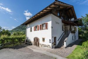 a white house with a wooden roof at Ferienwohnung Lafreid Algund in Lagundo