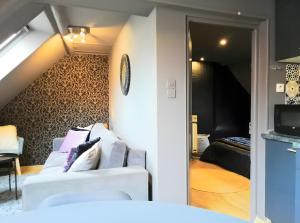 a living room with two white couches and a bedroom at Escale Glamour et Chic in Niederbronn-les-Bains