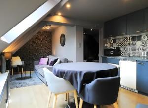 a kitchen and a living room with a table and chairs at Escale Glamour et Chic in Niederbronn-les-Bains