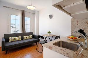 a kitchen and a living room with a couch and a table at Casa Sabrina, Terraza Vista Mar in Playa Honda