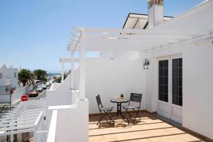 a balcony with a table and chairs on a white building at Casa Sabrina, Terraza Vista Mar in Playa Honda