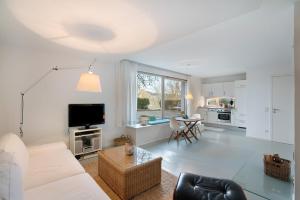 a living room with a couch and a tv at Modernes Apartment Ammersee in Windach