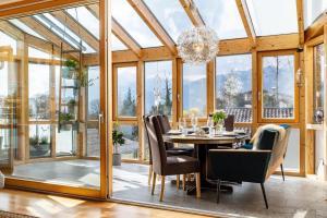 a dining room with a table and chairs and windows at Ferienwohnung Nearby in Thüringen
