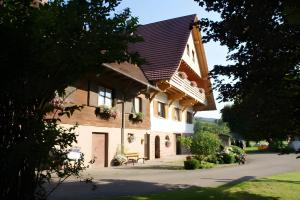 a house with a gambrel roof with flowers on it at Kornbauernhof in Oberharmersbach