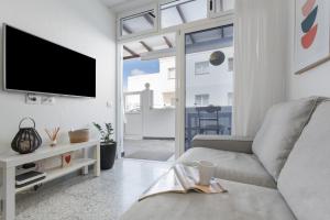 a living room with a couch and a tv at Casa Fabi in Arrieta