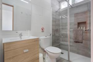 a white bathroom with a toilet and a shower at Casa Fabi in Arrieta +17 photos