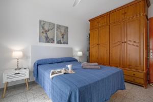 a bedroom with a blue bed and a large wooden cabinet at Casa Fabi in Arrieta