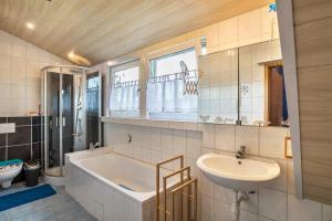 a bathroom with a sink and a bath tub and a sink at bei den Holzäppeln in Völkersweiler +34 photos