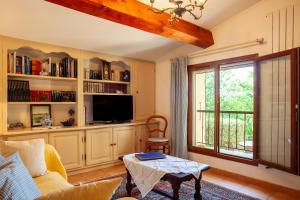 a living room with a couch and a tv and a table at Les Cigales in Ceyreste