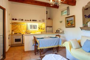 a kitchen and living room with a table and a couch at Les Cigales in Ceyreste