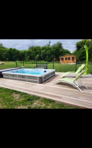 a deck with a pool and a chair and a chairractor at Chambres D'hôtes in Videcosville