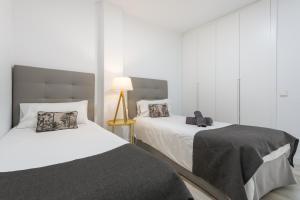a bedroom with two beds and a lamp at Espectacular Y Amplio Las Américas in Playa de las Americas +23 photos