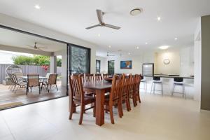 a dining room and kitchen with a table and chairs at Grand Parade in Buddina