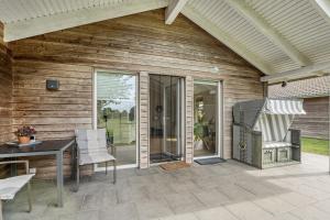 a patio with a table and a chair on a house at Nordlicht in Fehmarn