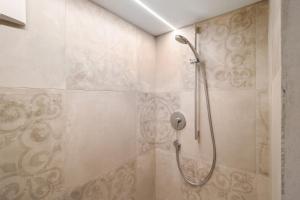 a shower with a shower head in a bathroom at Ansitz Baumannhof Apt 1818 in Falzes