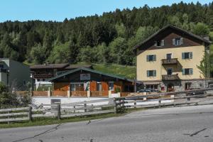 a large building with a fence in front of a house at Apartment Blaser in Mühlbachl